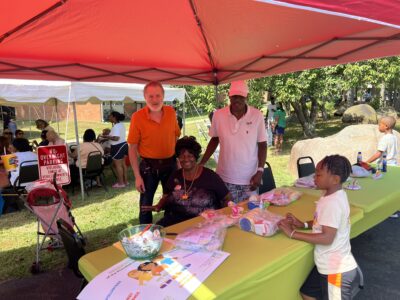 Board members at a craft table helping a kid