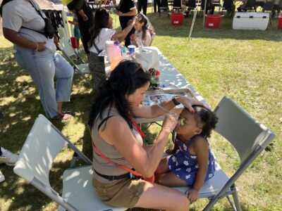 Woman painting a kids face